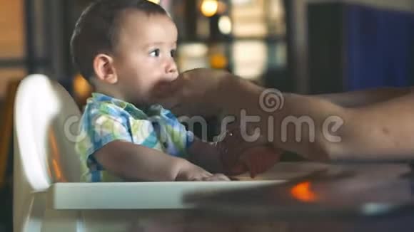 妈妈用嘴和手对着可爱的宝宝一个迷人的孩子笑和拍手可爱的小宝宝吃她视频的预览图