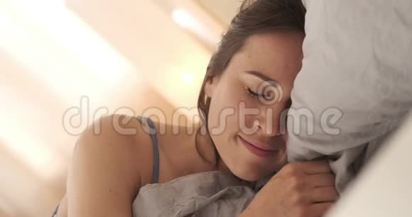 快乐的女人醒来在床上伸展视频的预览图