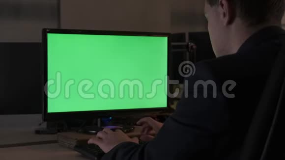 一位年轻的办公室男工人坐在办公桌前在电脑彩色显示器上工作库存数据视频的预览图