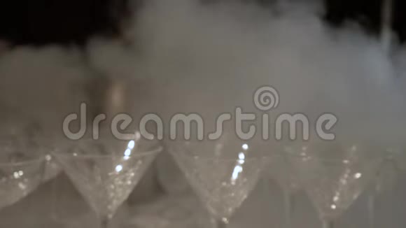 冰冷白色的烟雾沿着一排蔓延在桌子上空着马提尼玻璃把摄像机从大量的视频的预览图