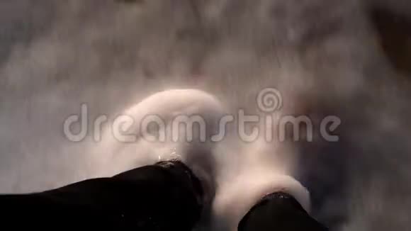 女孩穿着黑色牛仔裤的腿在潮湿的沙子上贝壳洗着冲浪用泡沫波浪视频的预览图