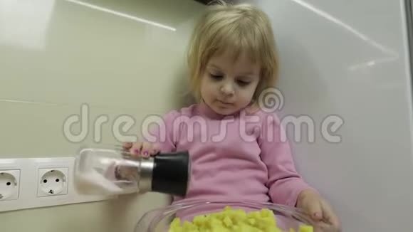 小女孩正坐在厨房里准备沙拉视频的预览图