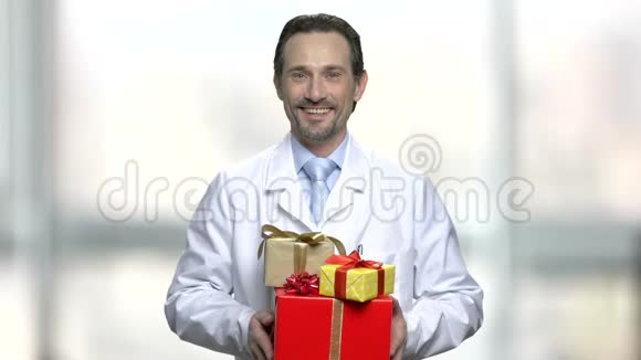 微笑的医生拿着一堆礼物盒视频的预览图
