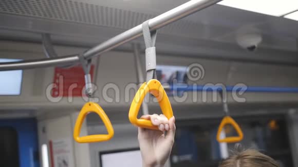 年轻女孩坐地铁车在智能手机上使用互联网视频的预览图