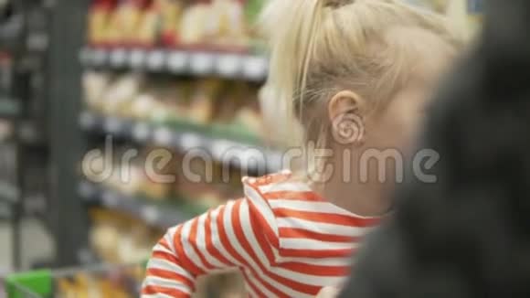 小有趣的女孩在超市里骑手推车视频的预览图