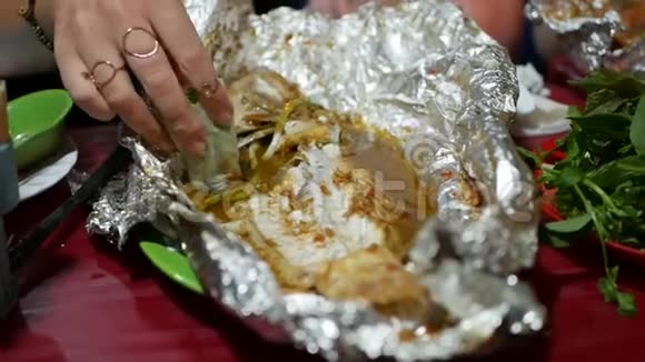 在亚洲街头食品市场游客吃春卷和用箔纸煮熟的鱼关门视频的预览图