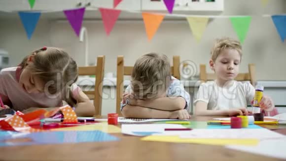 两个男孩和女孩坐在桌边一个不想画画除了用铅笔画画视频的预览图