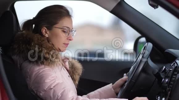 一个戴着眼镜的女孩开着一辆车她关掉了车走了出去视频的预览图
