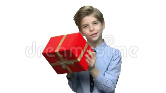 可爱的男孩摇动大礼盒视频的预览图