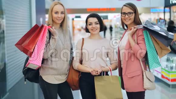 一幅漂亮女孩穿着时髦衣服的肖像以及在大型购物中心拿着购物袋的配饰视频的预览图