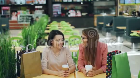 漂亮的女孩会说会笑坐在商场的咖啡馆里然后和朋友见面表达自己的想法视频的预览图