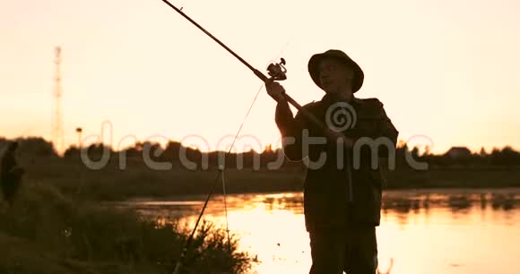 老渔夫的剪影背景是美丽的日落视频的预览图