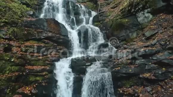 从高山上灰色的湿岩石落下来的泡沫水视频的预览图