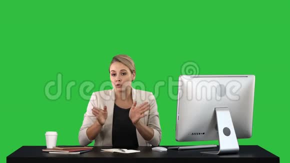 可爱的女商人看着办公室里的摄像机在绿色屏幕上交谈Chroma键视频的预览图