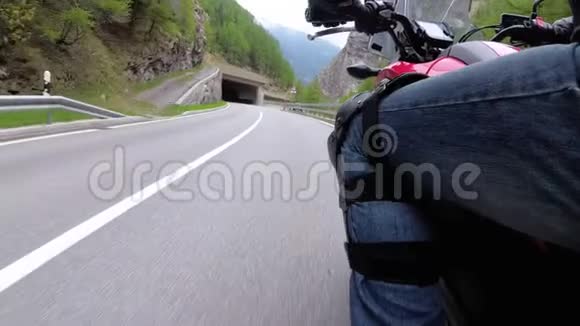 摩托车手沿着隧道中的风景山曲线路行驶侧视POV视频的预览图