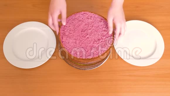 女人手把不同颜色饼干的蛋糕放在不同的盘子里视频的预览图