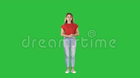 随意迷人的女人主持人按下想象中的按钮在想象中的屏幕上的绿色屏幕色度键视频的预览图