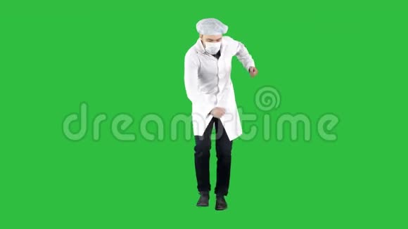 医生穿着他的制服戴着面具他在绿色屏幕上以一种有趣的方式行走铬钥匙视频的预览图