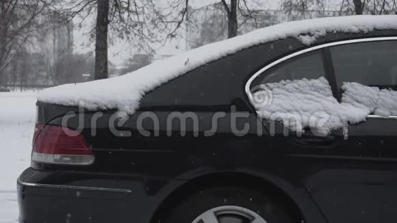 冬天白天降雪时雪躺在汽车上恶劣的天气条件交通暴风雪旅行的危险视频的预览图