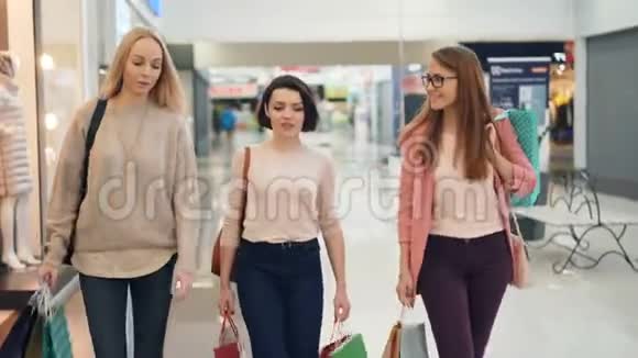 周末漂亮的女孩们拿着纸袋在购物中心边聊天边微笑内饰不错视频的预览图