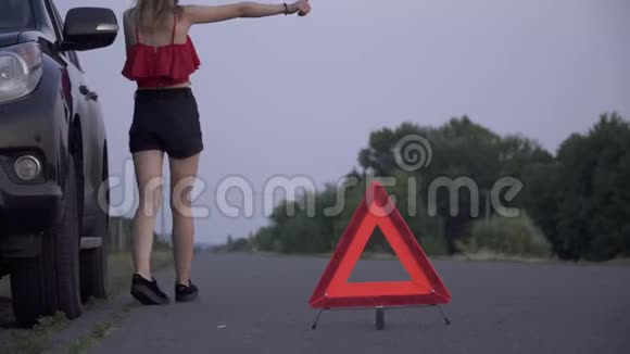 4女青年站在断车旁女青年正想开车去救她的女青年正在打电话给车上的麻烦视频的预览图