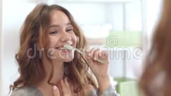微笑的女人在浴室里刷牙前镜牙科和口腔卫生视频的预览图