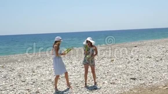 年轻漂亮快乐的女人手里拿着玉米在海滩上跳着滑稽的舞蹈视频的预览图