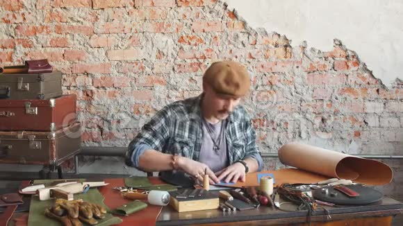 年轻的勤劳的人用手工工具加工皮革视频的预览图