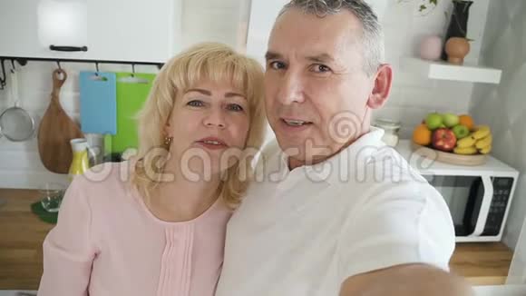 美国男人和女人微笑着交谈在家看手机摄像头视频的预览图
