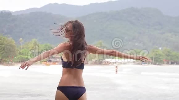 穿比基尼的年轻开朗的女人在海滩上跳舞很有趣视频的预览图