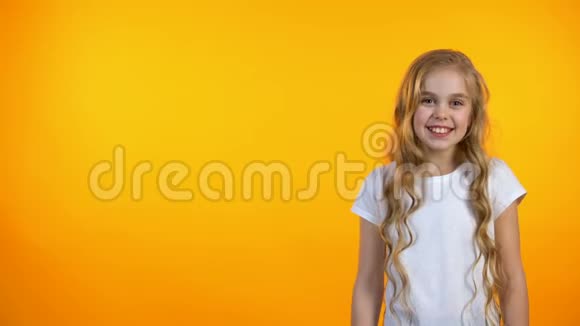 快乐可爱的女孩笑站在橙色的背景上幽默和笑话视频的预览图