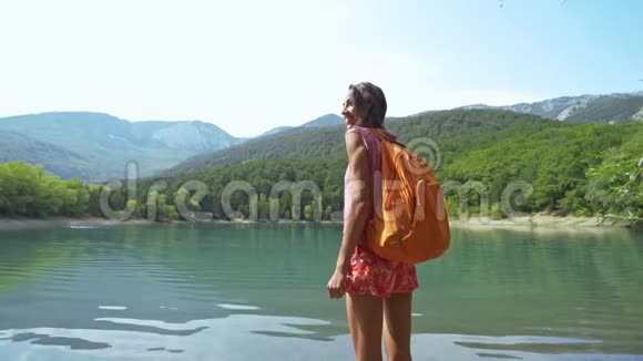 女徒步旅行者欣赏山湖景观视频的预览图