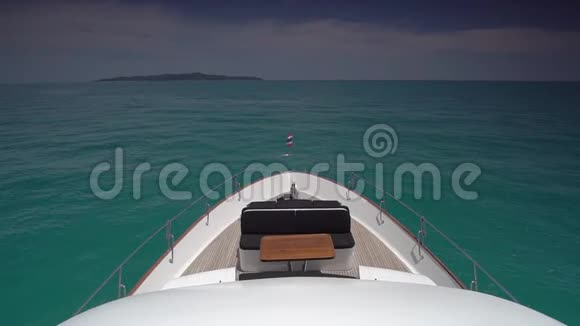 大白游艇沿着蔚蓝的海水航行前甲板的顶部景色舒适的沙发可以放松视频的预览图