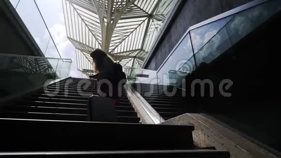 带手提箱的女乘客在车站上楼梯视频的预览图