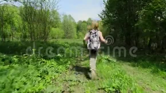 快乐的少女沿着春天的森林草坪奔跑视频的预览图