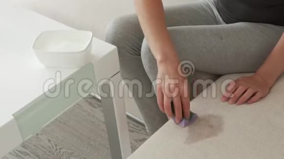 这位女士用浸在洗涤剂中的海绵从软垫家具上去除脏污视频的预览图