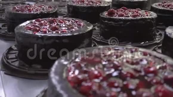 在生产中用新鲜樱桃浆果装饰和制作巧克力饼干蛋糕的奶油装饰视频的预览图