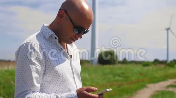 男人用和滚动手机背景下的一个乡间小路夏天中弹视频的预览图