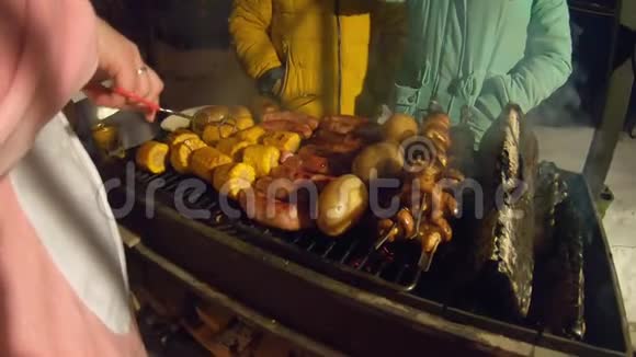 空中烧烤烤肉香肠和蔬菜着火冬天晚上做饭人们站在烧烤周围烟雾从视频的预览图