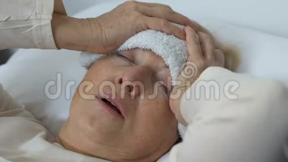 生病的老太太用湿毛巾抱着头发烧视频的预览图