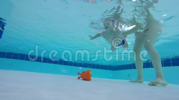 一个玩具被一个婴儿从游泳池的底部提起视频的预览图
