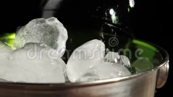 新鲜啤酒一个绿色的瓶子和美味的工艺啤酒旋转桶与冷的真正的冰在黑色的背景下视频的预览图