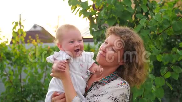 快乐的母亲和宝贝女孩带着笑脸的宝宝正在妈妈手上挥手视频的预览图