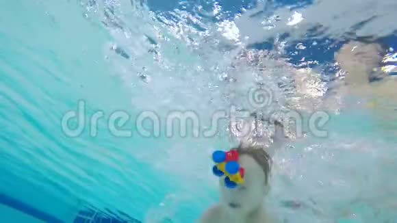 小男孩正在游泳池里拿着玩具在水下游泳视频的预览图