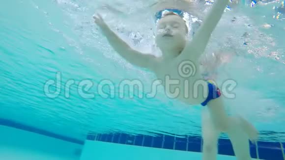 一个孩子学习游泳的水下镜头视频的预览图