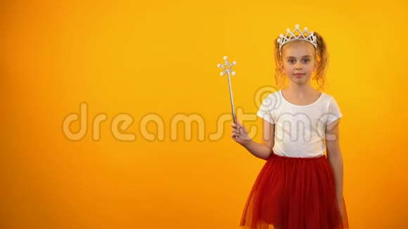 可爱的女孩穿着仙女的服装看着镜头小公主在玩魔杖视频的预览图