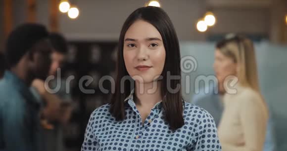 年轻成功女商人站在办公室工作空间看相机的肖像工作人员在模糊的视频的预览图