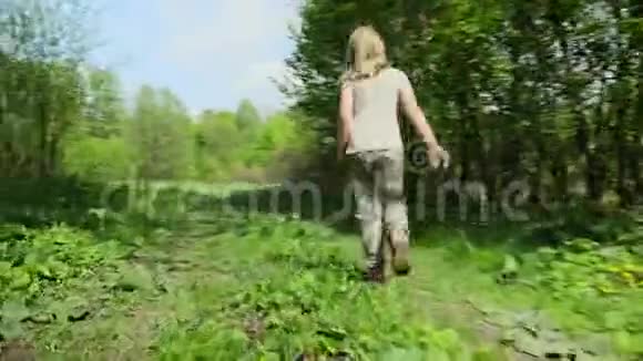 快乐的少女沿着春天的森林草坪奔跑视频的预览图