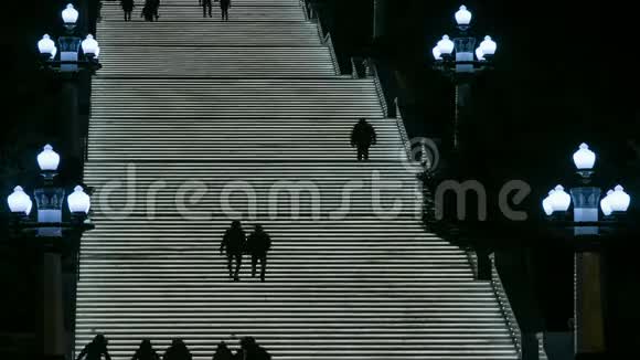 晚上人们走在发光的楼梯上视频的预览图