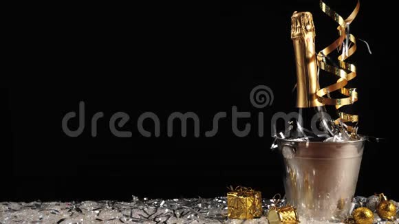 好香槟酒手从桶里拿一瓶起泡酒在黑背景下的白雪上放着真正的冷冰视频的预览图